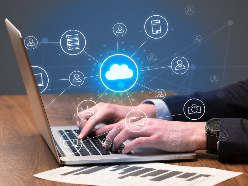 Image of a worker on a laptop with cloud systems symbols overlapping the image
